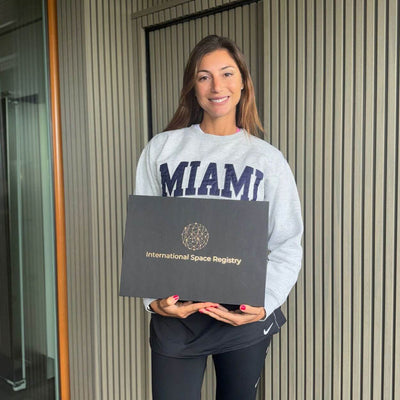 Une cliente tient son coffret cadeau International Space Registry.